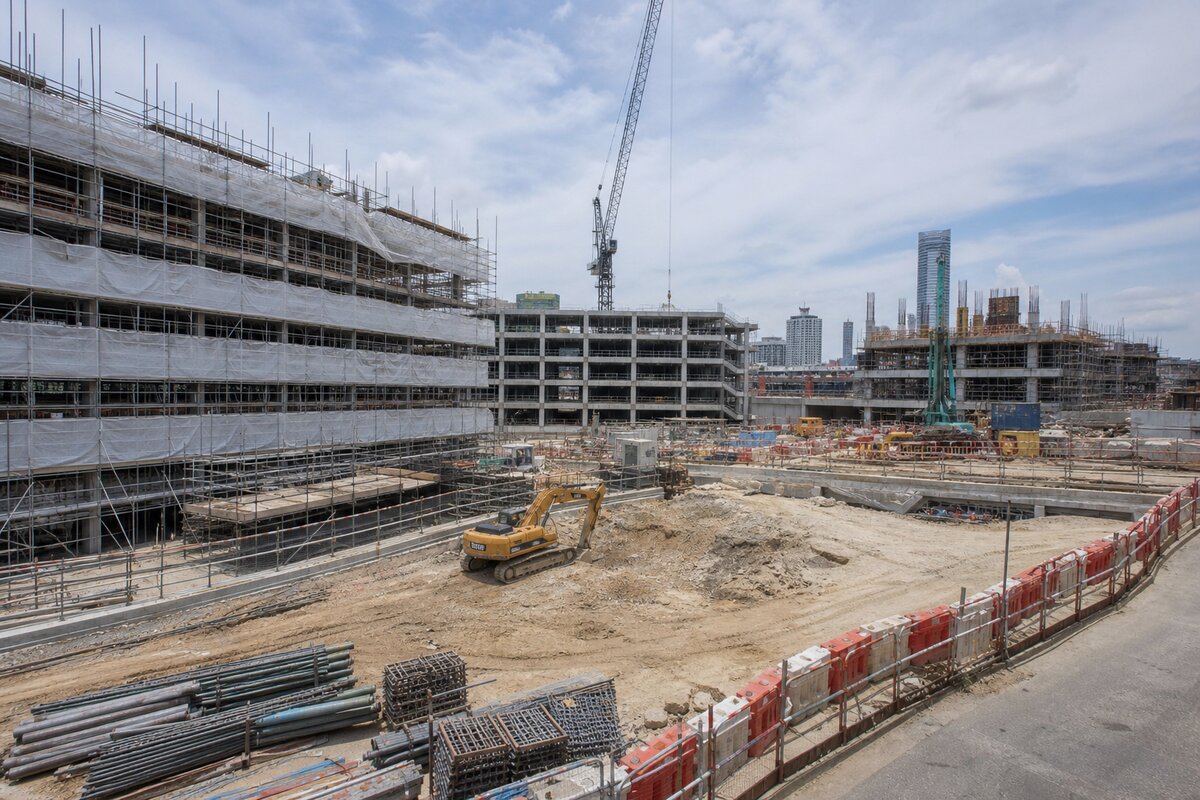 Active multi-site construction landscape with scaffolding, plant, and job-site equipment
